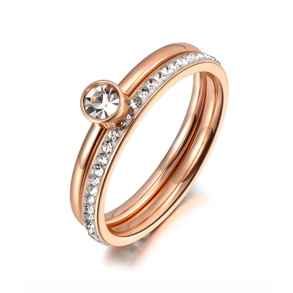 ROZĀ ZELTA TOŅA GREDZENS AR CENTRĀLO KUBISKO CIRKONIJU UN AKMEŅU RINDU